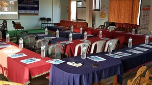 A conference room with tables set up for a meeting, equipped with water bottles and nameplates. - Hotel Peace Palace (Baglung)