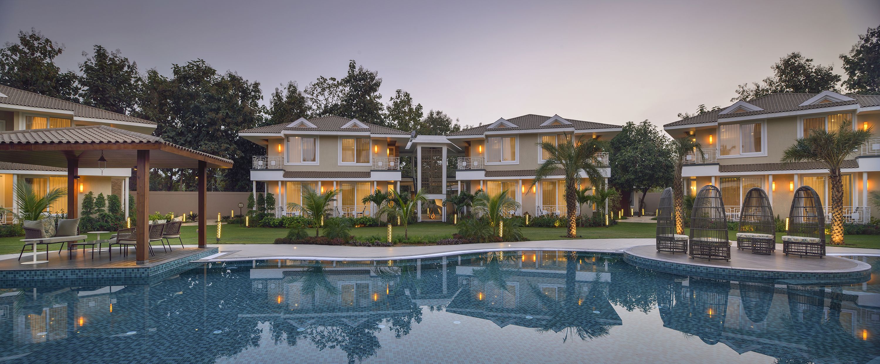 Un resort con piscina, edificios de varios pisos y zonas de estar al aire libre.