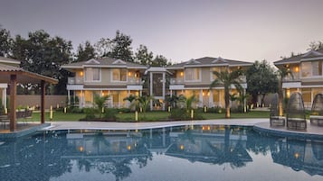 Un resort con piscina, edificios de varios pisos y zonas de estar al aire libre.