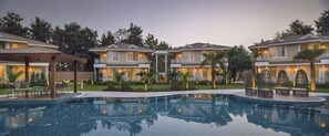 Ein Resort mit Schwimmbad, mehrstöckigen Gebäuden und Außenbereich-Sitzgelegenheiten.