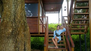 Une cabane en bois avec un escalier menant à un balcon.