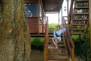 A wooden cabin with a staircase leading to a balcony.