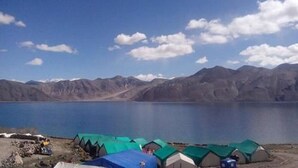 A lakeside campsite with tents and a clear view of mountains in the background. - Nomad Camp (Leh)