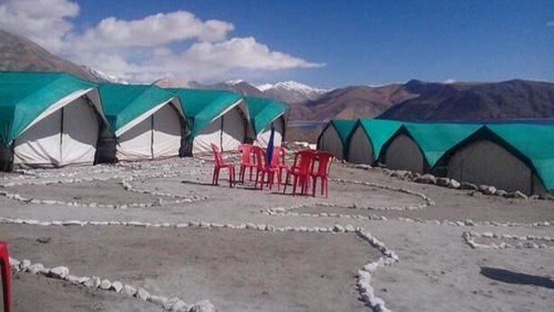 A series of tents with a view of snow-capped mountains in the background. - Nomad Camp (Leh)