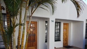 A building with two wooden doors, a number 14 sign, and a small entrance with a doormat. - Eskulaap Hotel and Conference (Polokwane)