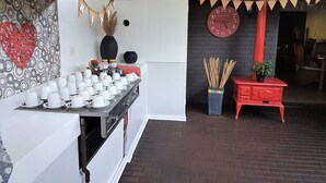 A kitchen area with a counter displaying white cups and saucers, a black vase, and a red heart decoration on the wall. - Eskulaap Hotel and Conference (Polokwane)