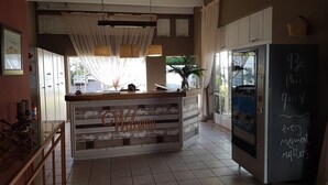 A kitchen with a wooden island, a refrigerator, and a chalkboard with a message. - Eskulaap Hotel and Conference (Polokwane)
