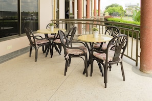 Guests can dine or meet in this outdoor space with tables and chairs.