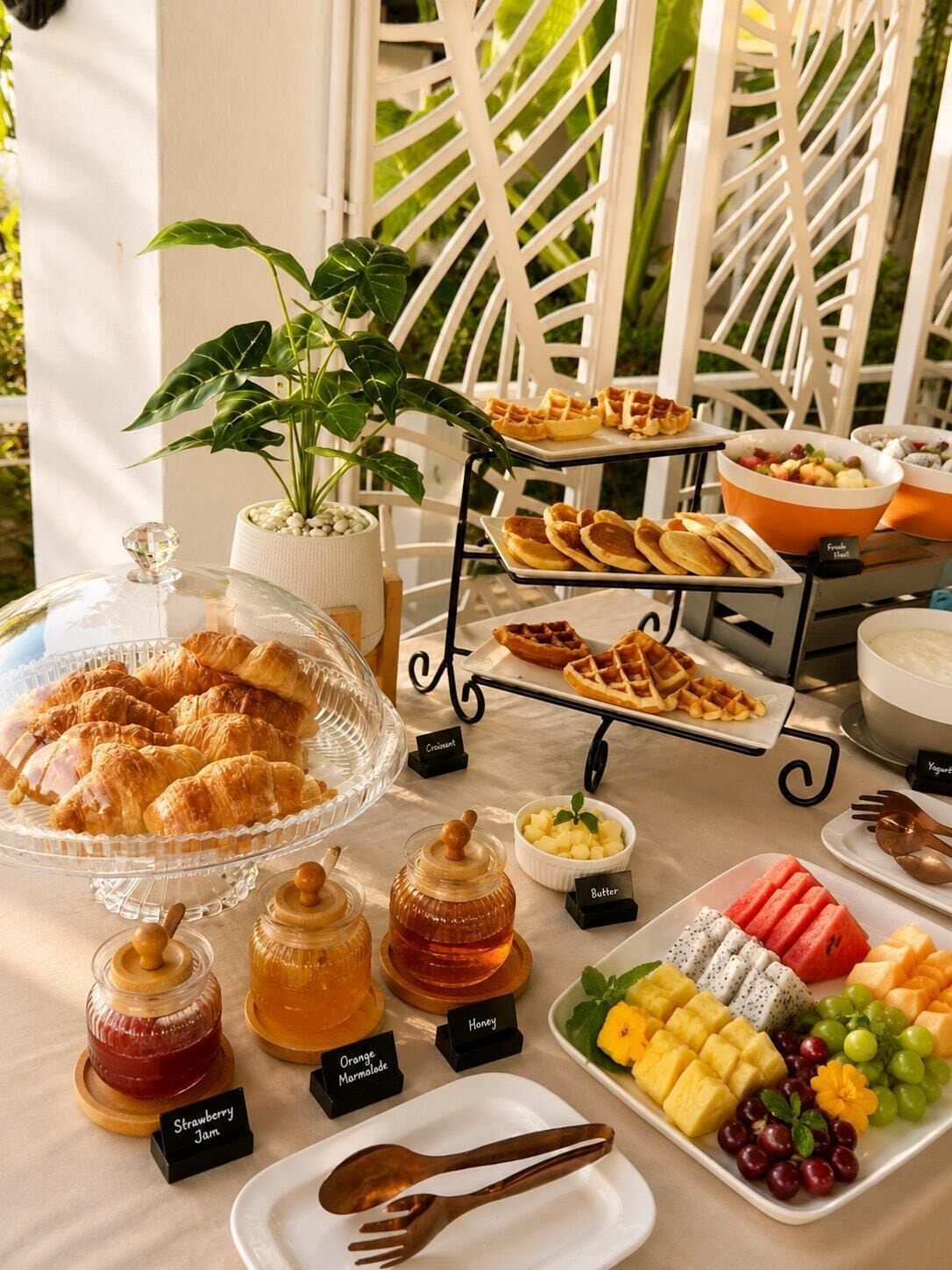 A breakfast buffet with various pastries, fruits, and condiments.