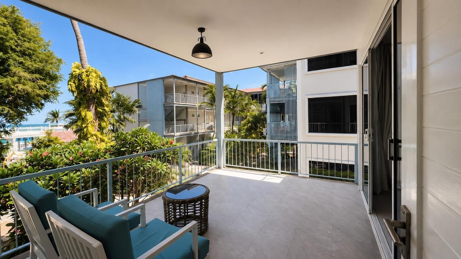 A balcony with a sofa, a small table, and a railing.