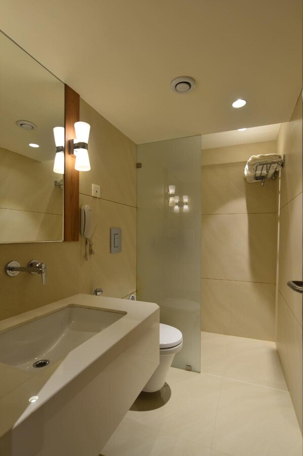 Un baño moderno con una bañera grande, un inodoro y una cabina de ducha de vidrio.