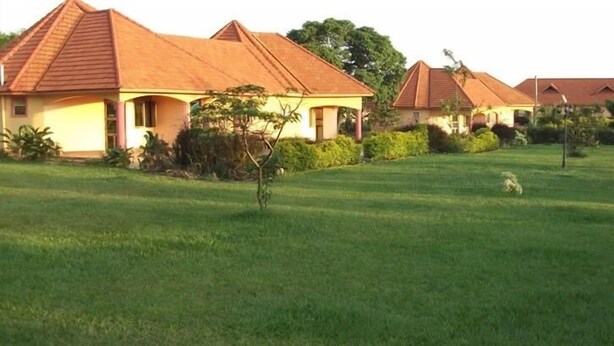 A row of houses with red roofs and a well-maintained lawn.