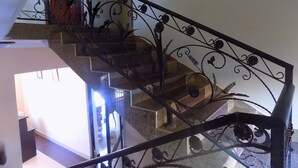 A staircase with ornate metal railings and a view of the interior space. - Olina Hotel and Apartments (Kampala)