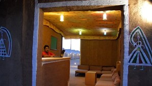 Una habitación con techo de madera, un sofá y un escritorio con una persona sentada.