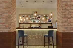 A bar area with two stools, a brick wall, shelves with bottles, and hanging pendant lights. - Hotel G9 (Zelenogorsk)
