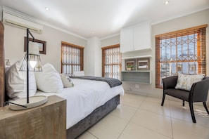 Een moderne slaapkamer met een bed, bedlamp en een bank.