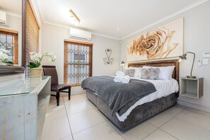 Un dormitorio moderno con una cama grande, un escritorio y una silla.