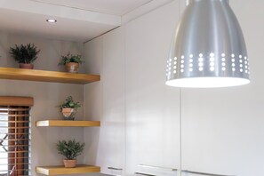 Een modern interieur met witte muren, houten planken en planten in potten.