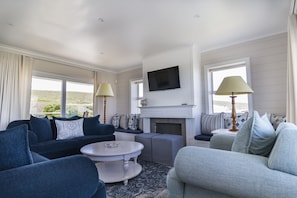 Departamento Deluxe, 2 habitaciones, vista al mar, frente al mar | Área de sala de estar | Televisión de pantalla plana de 32 cm con canales vía satélite