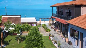 A coastal property with a paved patio, a covered seating area, and a view of the sea. - Kamelia & Semeli Hotel (Thasos)