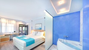 A modern hotel room with a large bed, a separate bathroom with a bathtub, and a desk area. - Kamelia & Semeli Hotel (Thasos)