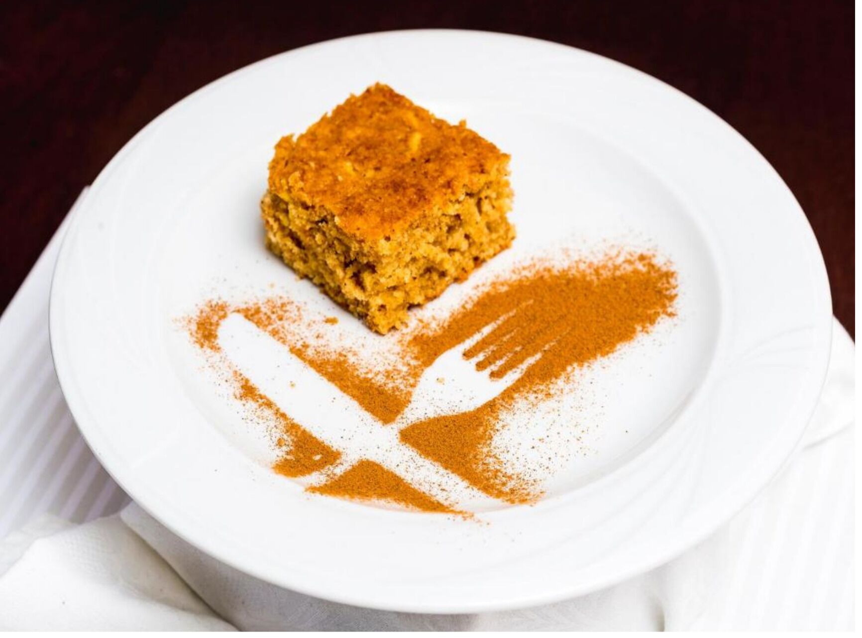 Un plato blanco con un pedazo de comida y un símbolo de cuchara y tenedor dibujado.