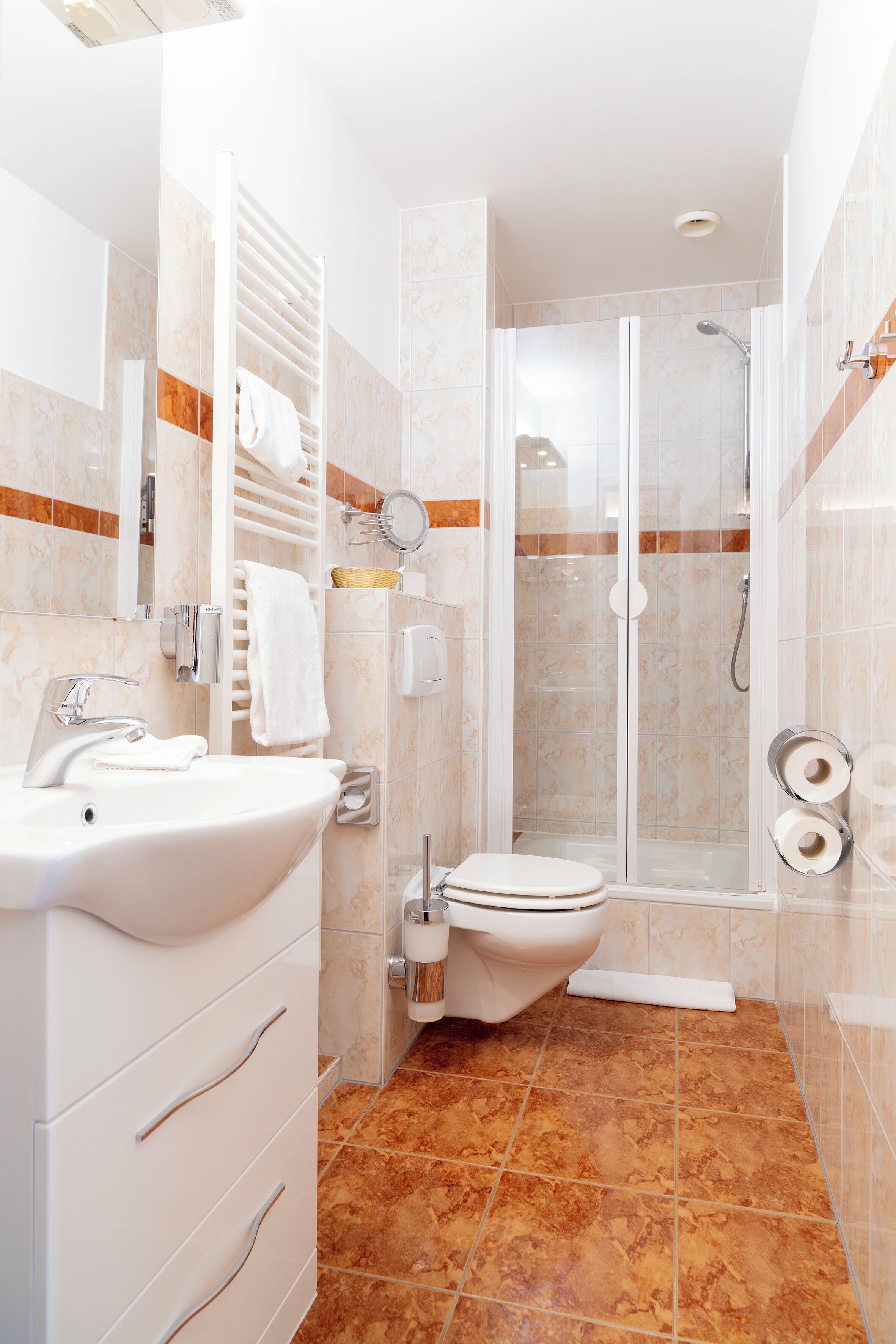 A modern bathroom with a sink, toilet, and shower.