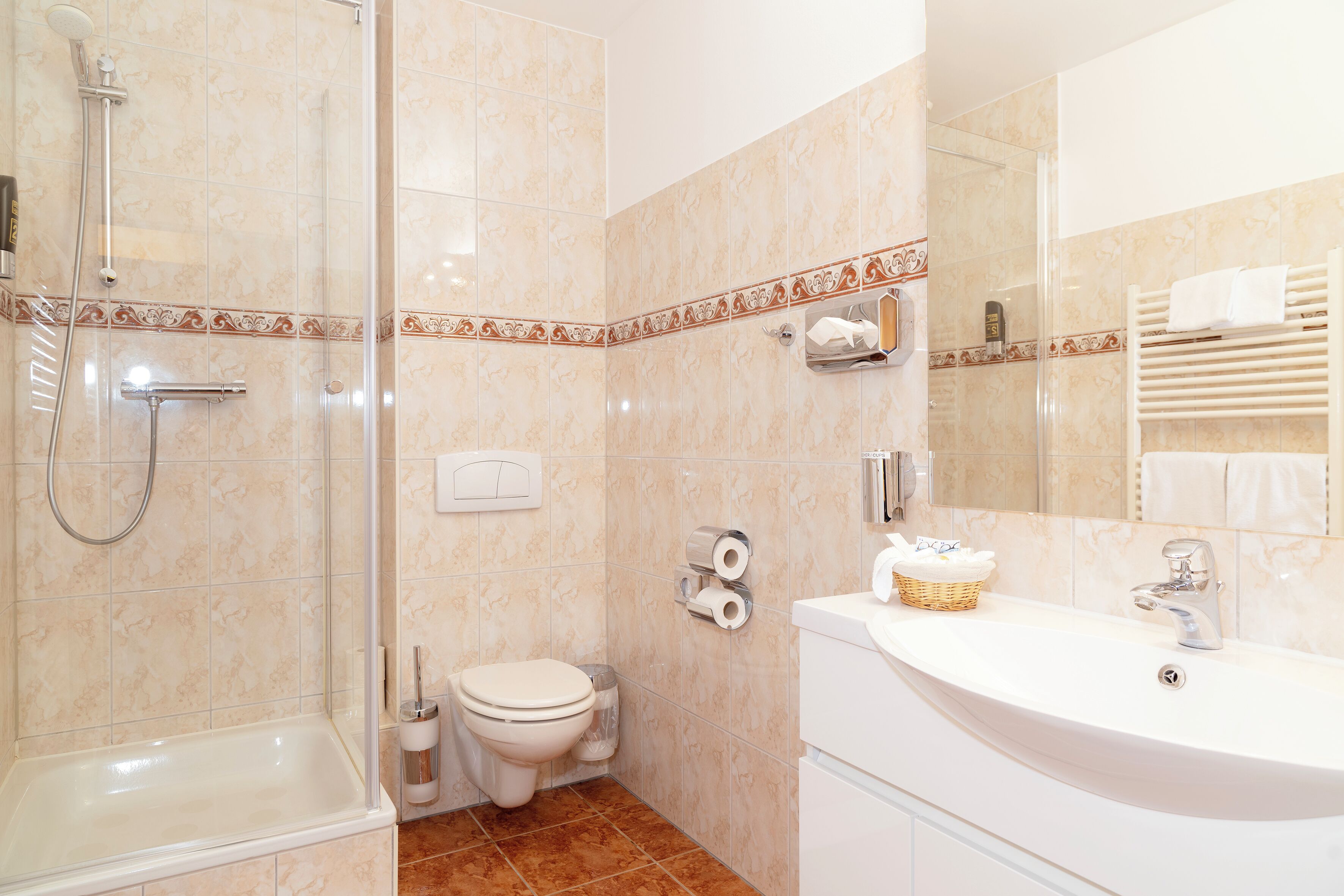 Ein Badezimmer mit Dusche, Toilette und Waschbecken.