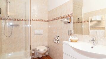 Ein Badezimmer mit Dusche, Toilette und Waschbecken.
