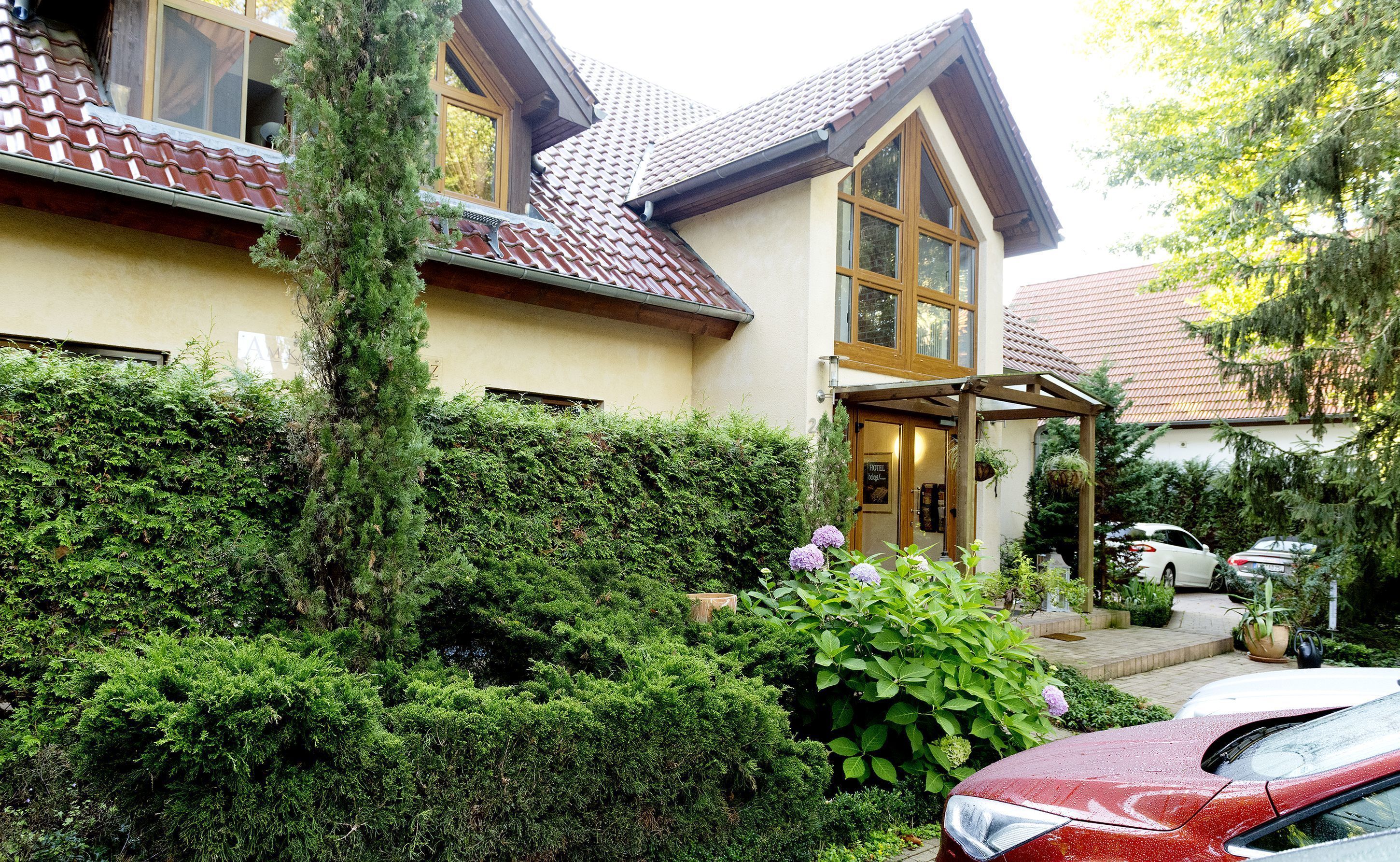 A two-story building with a tiled roof, a wooden entrance, and a covered porch.