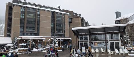 Un edificio con fachada de vidrio amplia y un espacio exterior cubierto con nieve.