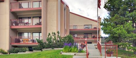 A multi-story hotel with balconies, a flagpole, and a well-maintained lawn.