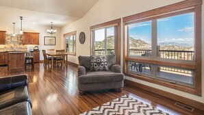 A spacious living room with a large window offering a view of a mountainous landscape.
