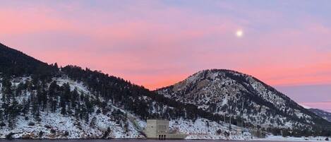 A mountain landscape with a building near a body of water.