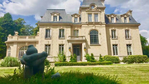 Un grand bâtiment imposant, doté d’une architecture symétrique, de nombreuses fenêtres et d’une entrée centrale.