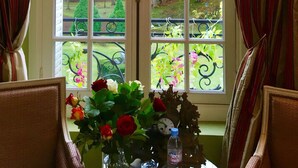 Une pièce dotée d’une grande fenêtre donnant sur un jardin aux couleurs automnales.