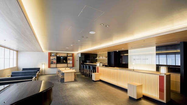 A modern hotel lobby with a reception desk, bar area, seating, and a piano. - FIRST CABIN Kyoto Kawaramachi Sanjo (Kyoto)