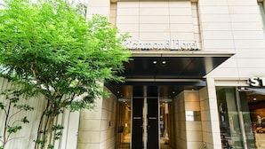 The entrance to Richmond Hotel with a modern facade, glass doors, and a sign above the entrance.
