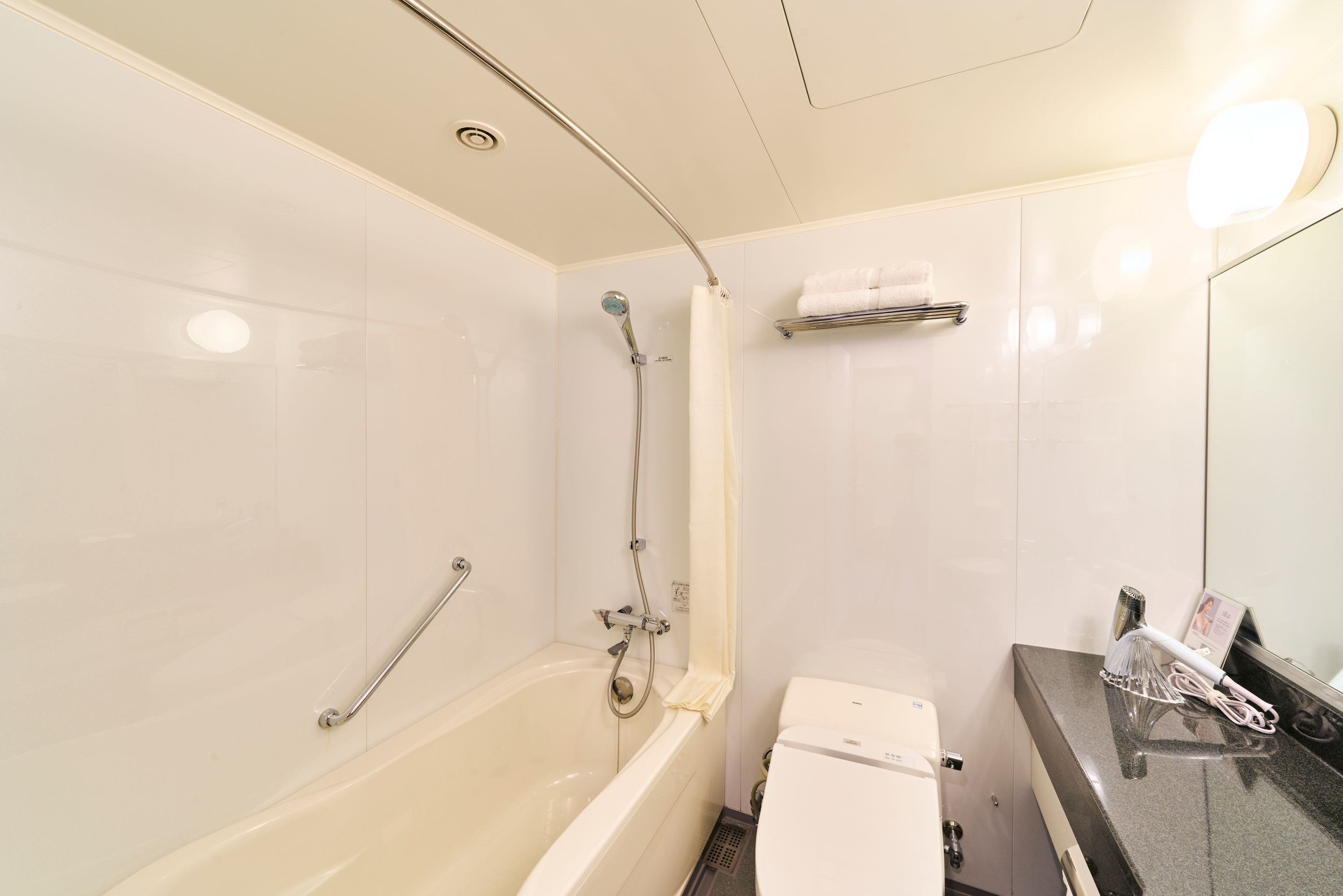 Bañera con ducha, secador de pelo, pantuflas, bidet