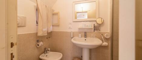 Baño con lavabo, bidé y espejo.