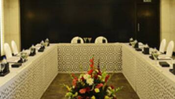 A conference room with a long table, chairs, and a floral centerpiece.