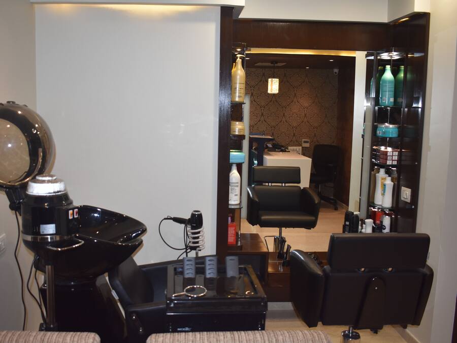 A salon with a hairdryer, mirrors, and a seating area.