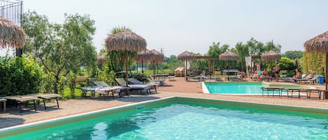 Alberca al aire libre por temporada y sombrillas en la alberca