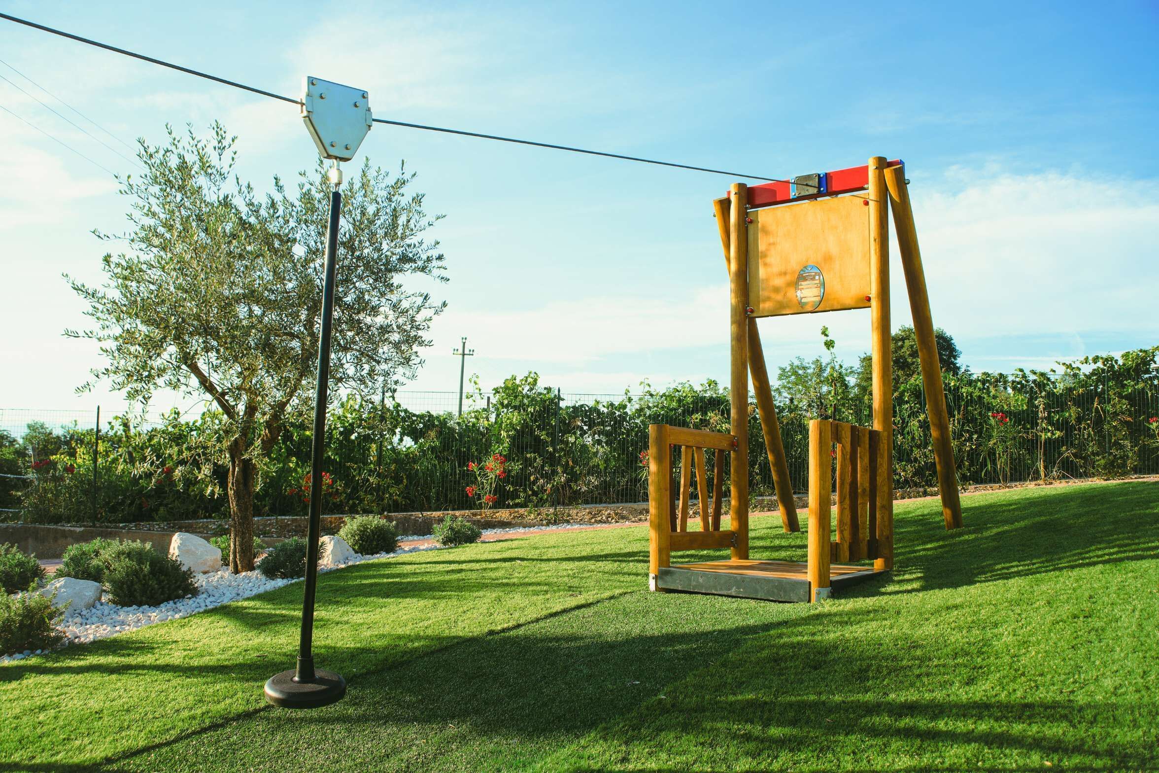 A swing set in a well-maintained grassy area with a clear sky.