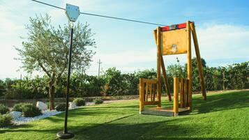 A swing set in a well-maintained grassy area with a clear sky.