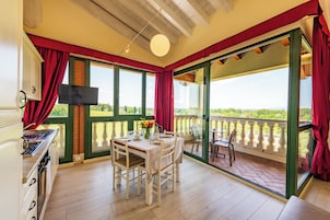 Suite, 2 camere da letto, balcone, vista lago | Area soggiorno | TV a schermo piatto 32 pollici con canali satellitari, TV