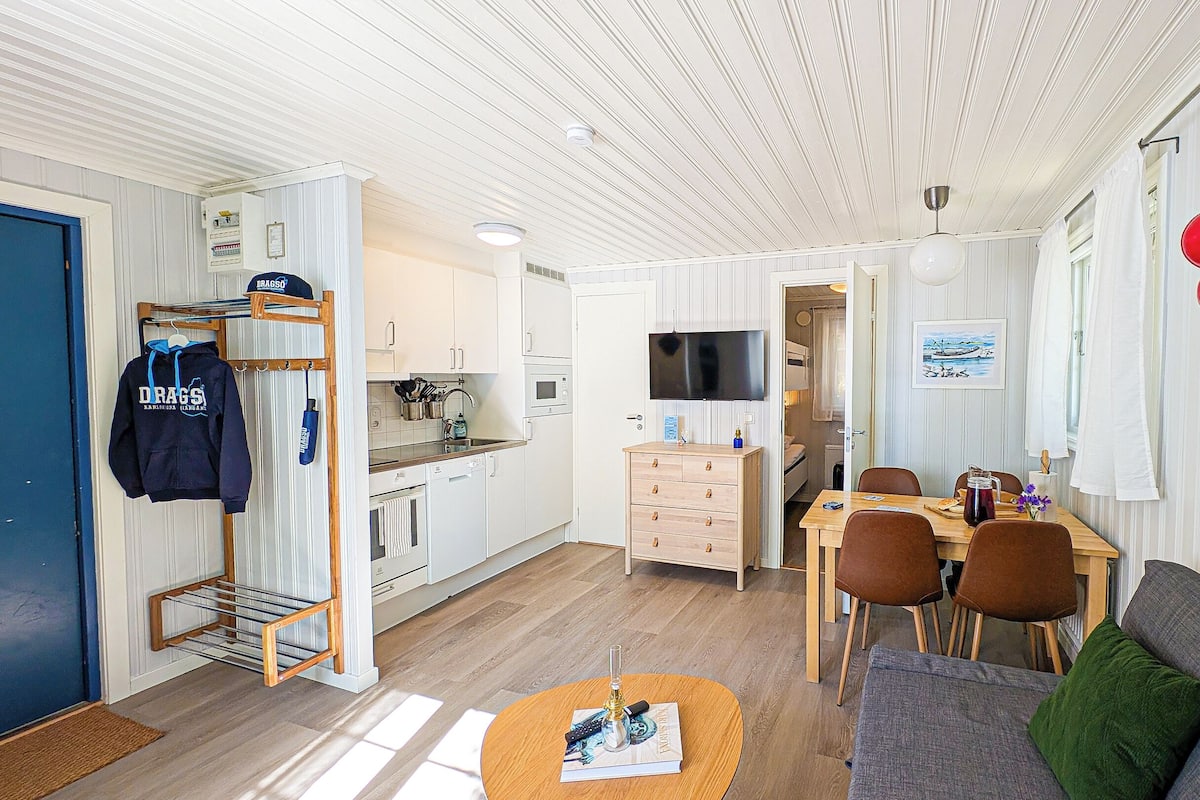 A compact living space with a kitchenette, a dining area, and a seating area.