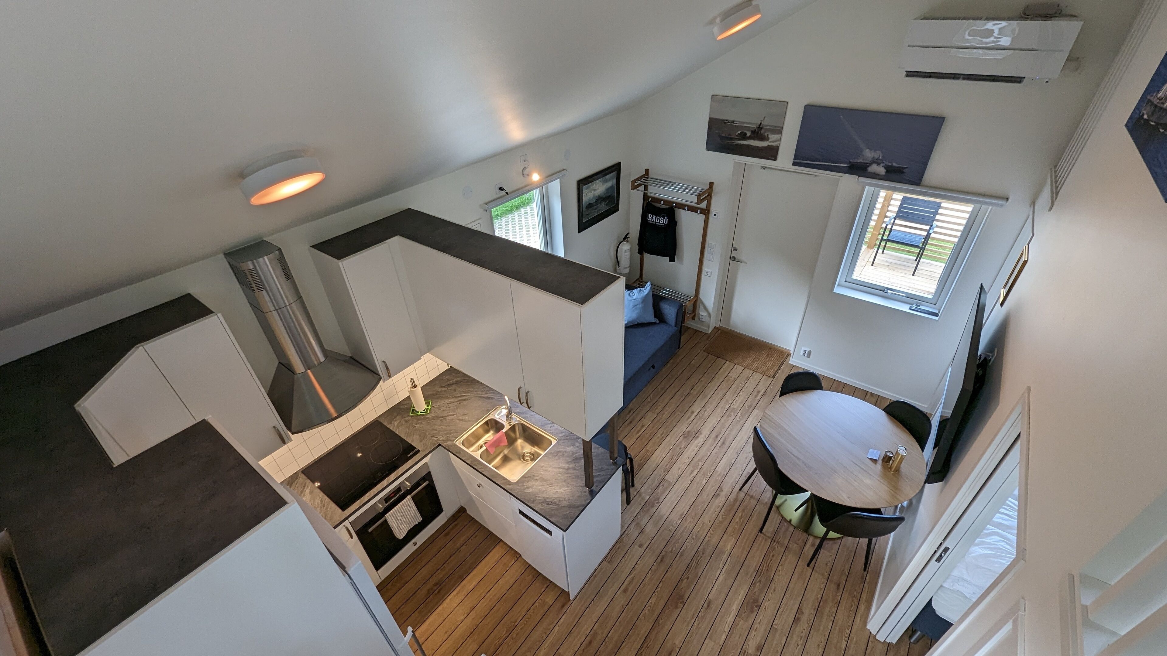 A compact kitchen with a sink, stove, and dining area with a table and chairs.
