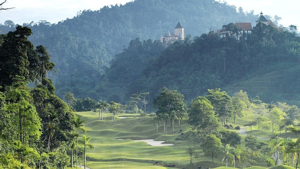 A golf course with a winding path, sand bunkers, and a distant building on a hill. - Berjaya Hills Golf & Country Club (Bukit Tinggi)