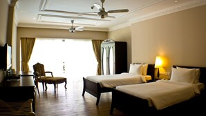A hotel room with two beds, a desk, a chair, a ceiling fan, and a lamp. - Berjaya Hills Golf & Country Club (Bukit Tinggi)